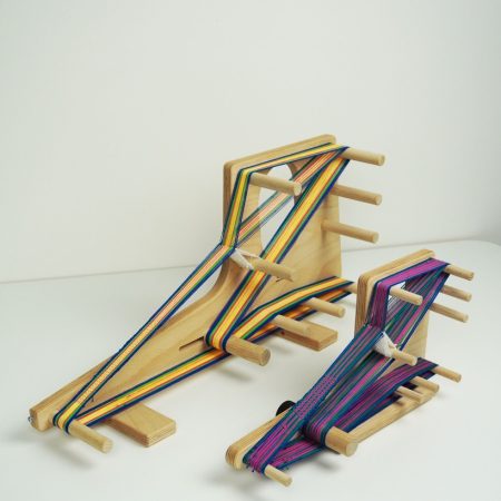 Louet Inkle Loom, 2 sizes, shown with a warp on each of them from an angle .