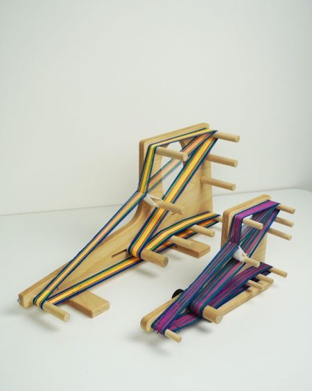 Louet Inkle Loom, 2 sizes, shown with a warp on each of them from an angle .